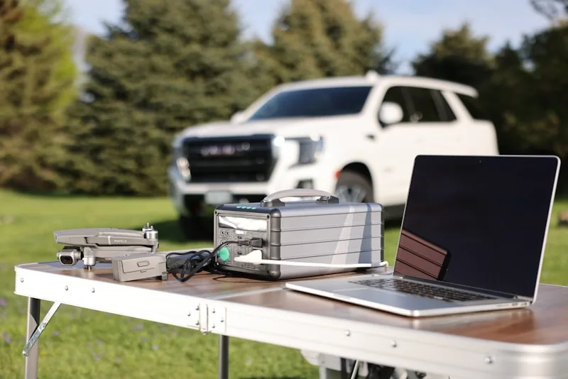 A portable power station connected to testing equipment on a workbench with multimeters and cables