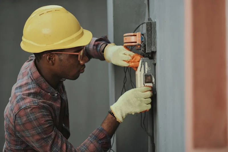 A technician's hands using a digital multimeter to measure electrical output from a power device