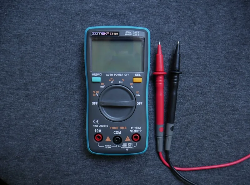 Close-up of a digital multimeter displaying voltage readings while testing a power bank's output