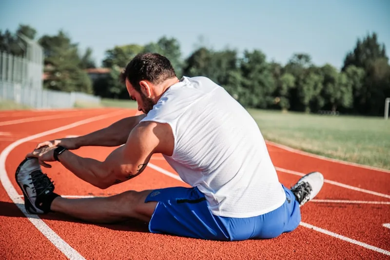 Person holding lower back while stretching or demonstrating pain relief techniques