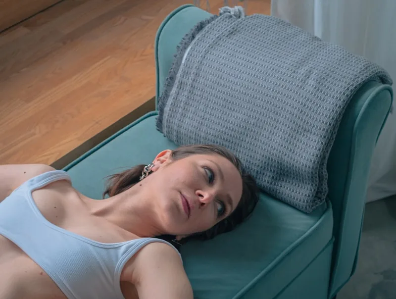 Person lying on an infrared mat at home during a relaxation therapy session