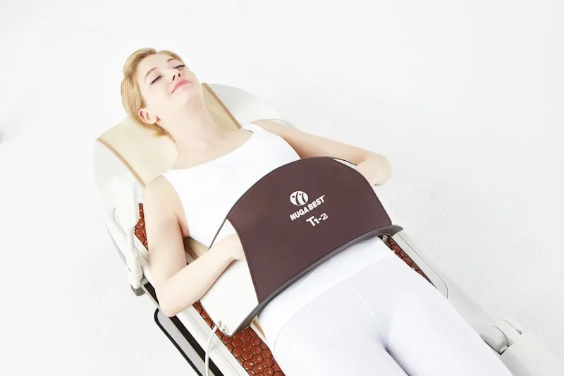 Person lying on an infrared therapy mat with warm red light glowing