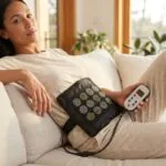 Person relaxing on a couch using a Therasage portable infrared Healing Pad