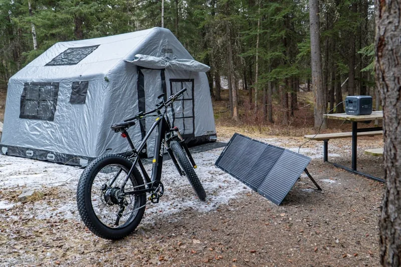 Portable power station with solar panel attachment being used during outdoor hiking or adventure travel