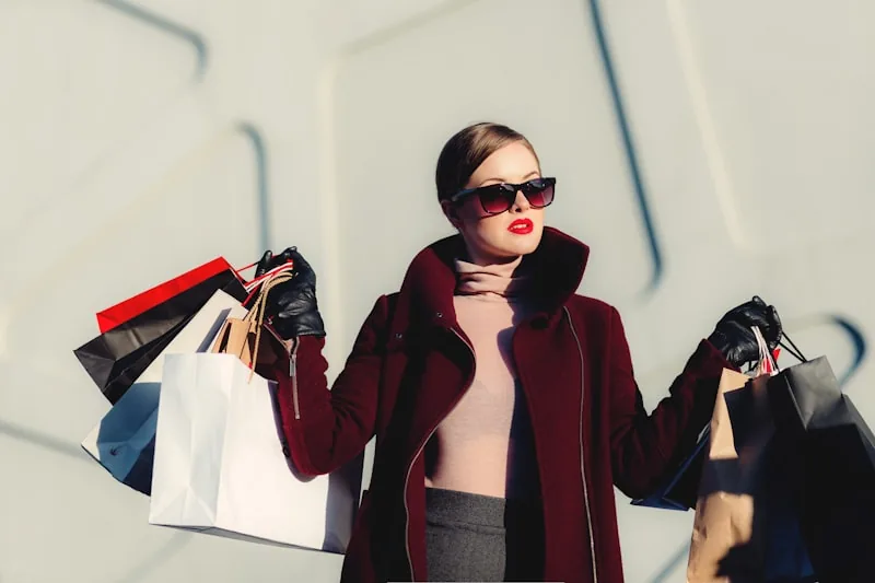 Shopper holding shopping bags with affordable streetwear purchases on a city street