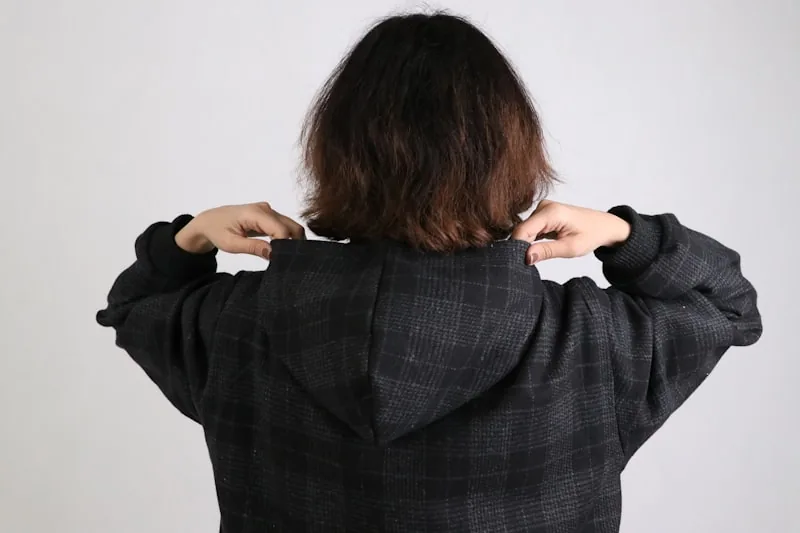 Someone checking the fit of a hoodie in a fitting room mirror
